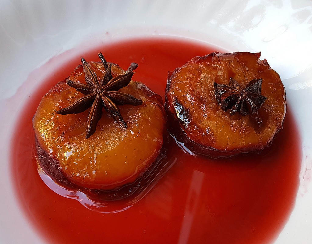 Baked plums in cherry sauce