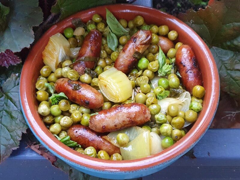 Pan-fried sausages with peas and leek