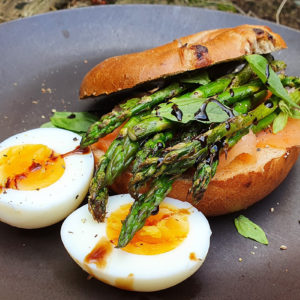 Pesto bagel with smoked salmon, egg and asparagus