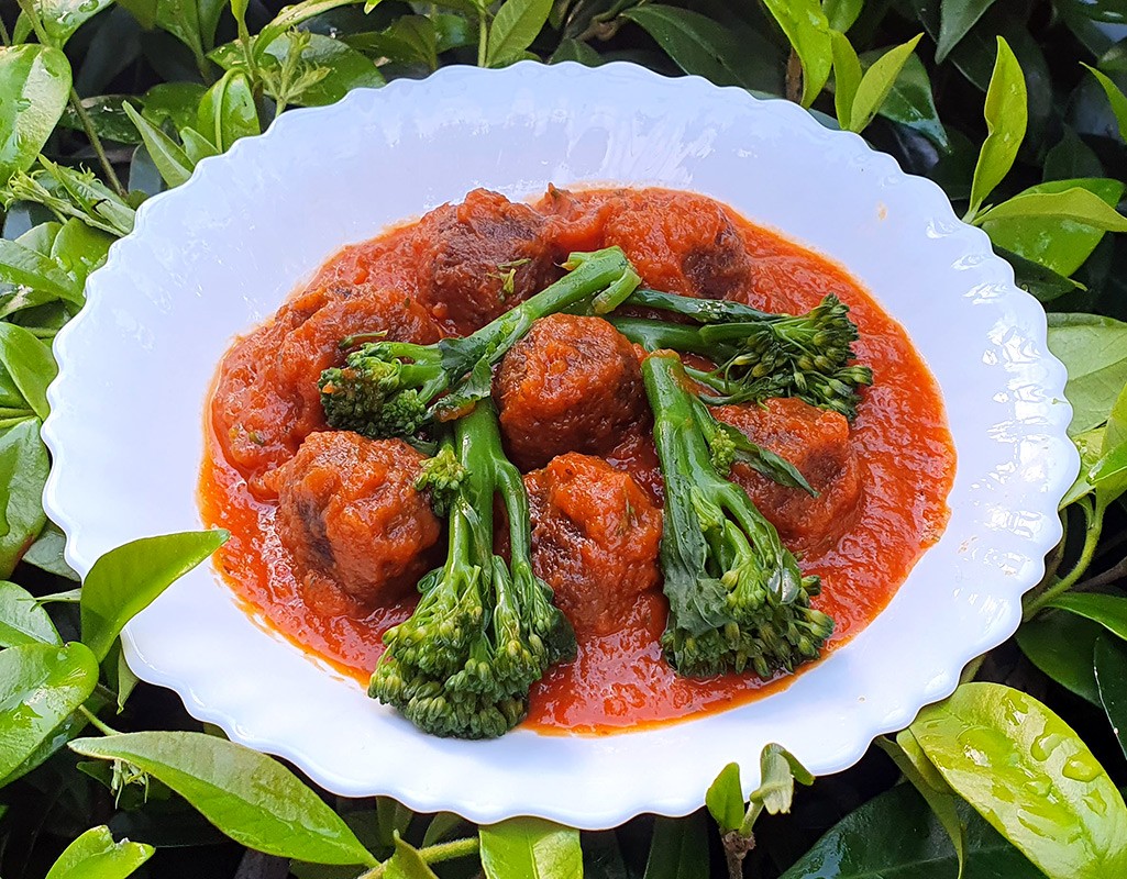 Meatballs with broccoli in red pepper sauce