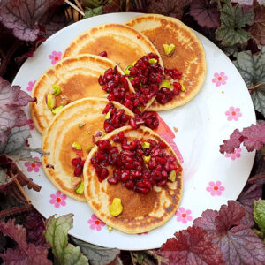 Orange pancakes with pomegranate and pistachio