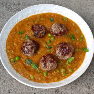 Meatballs in tomato and pea sauce