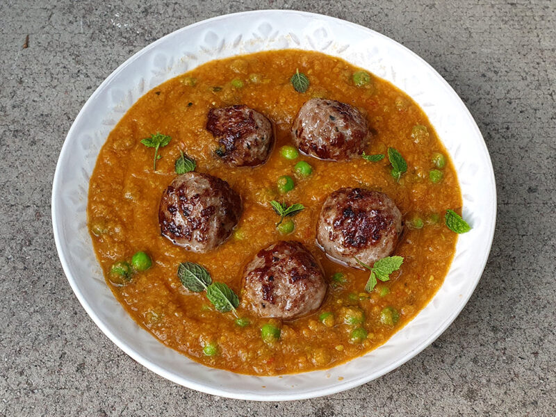 Meatballs in tomato and pea sauce