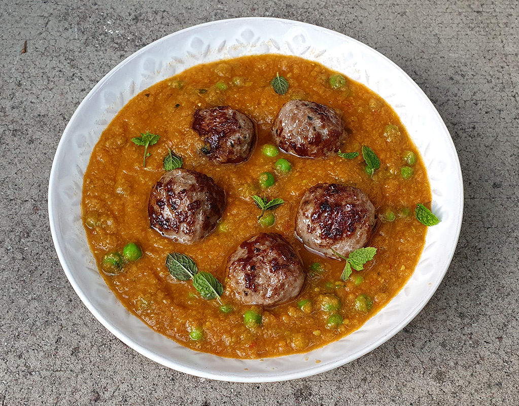 Meatballs in tomato and pea sauce